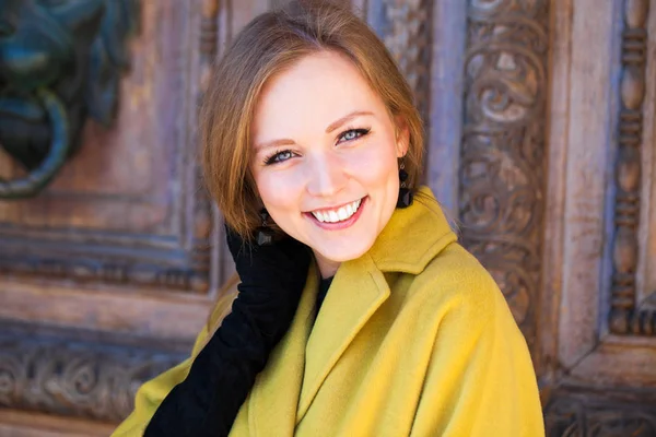 Portréja egy fiatal gyönyörű nő, a sárga kabát — Stock Fotó