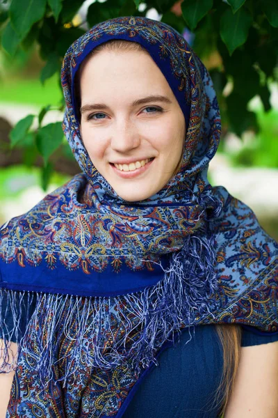 Happy young blonde woman in blue scarf, summer outdoors