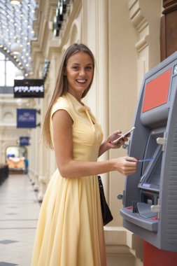 Arka planda alışveriş merkezi Atm üzerinde sarışın kadın