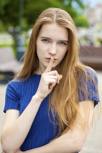 Junge schöne Frau hat Zeigefinger auf Lippen gelegt als Zeichen der Stille — Stockfoto