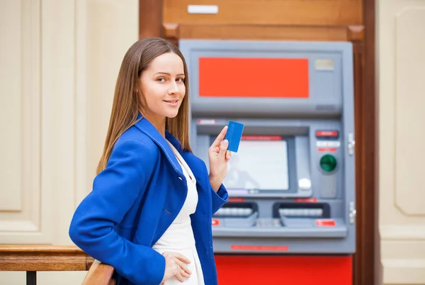 Young woman inserting a credit card to ATM — Stock Photo, Image