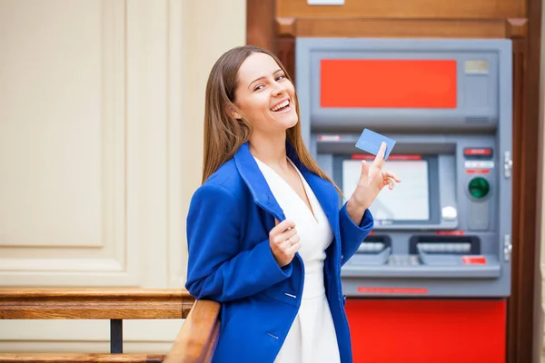 Jonge vrouw invoegen van een credit card naar Atm — Stockfoto