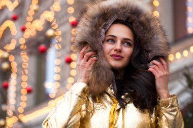 Altın ceketi giyen genç güzel kadın 