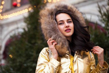 Altın ceketi giyen genç güzel kadın 