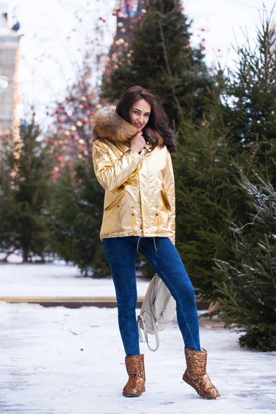 Молодая красивая женщина в золотом зимнем пальто — стоковое фото
