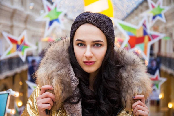 Belle femme brune en manteau de fourrure doré — Photo