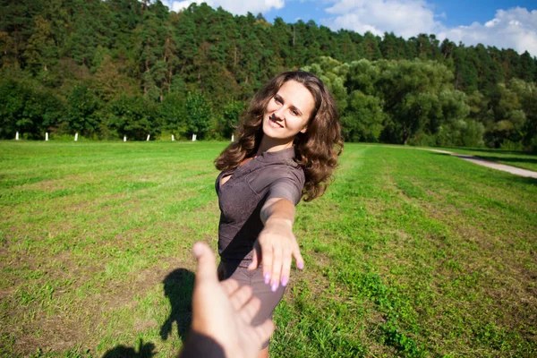 Följ mig, vackra unga kvinna håller handen på en man — Stockfoto