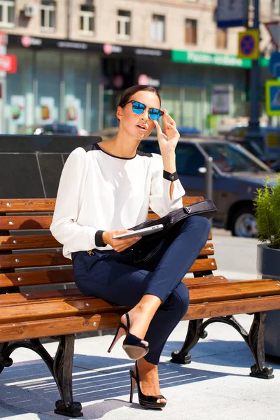 Hermosa mujer de negocios sentada en un banco — Foto de Stock