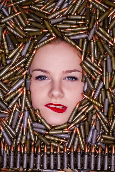 Portrait of young beautiful girl in hunting cartridges