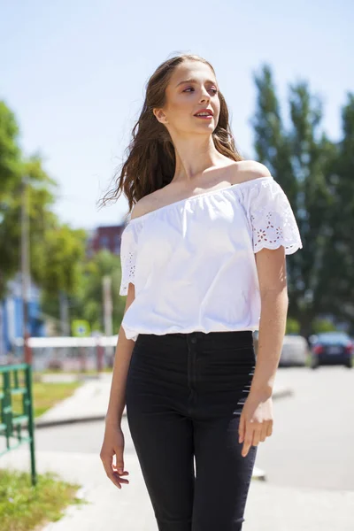 Jovem bela mulher morena em jeans e blusa branca andando — Fotografia de Stock