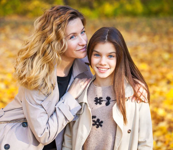 Happy mother and daughter are walking in the autumn park — Stock Photo, Image