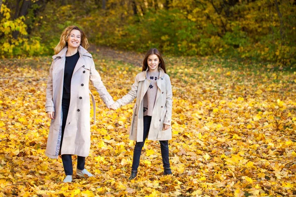 Feliz madre e hija están caminando en el parque de otoño — Foto de Stock