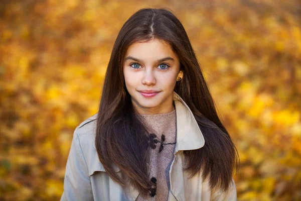 Счастливая маленькая девочка в бежевом пальто — стоковое фото