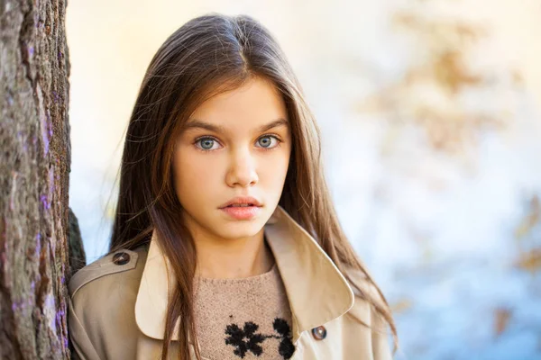 Gelukkig jong meisje in beige jas — Stockfoto
