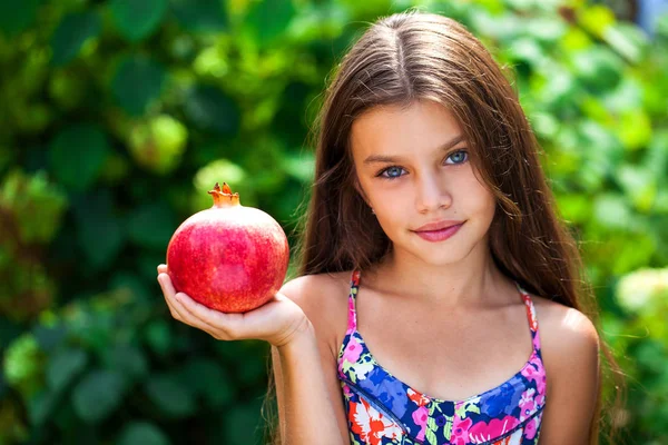 Happy little girl with pomegranate — Stock Photo, Image