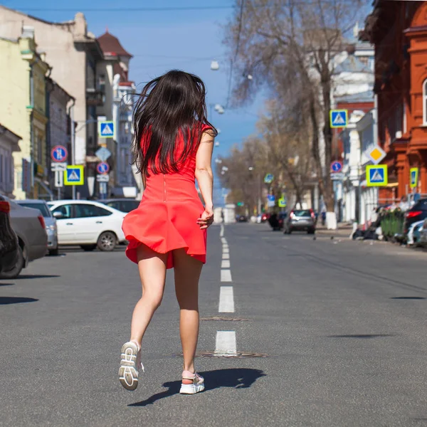 Νεαρή όμορφη γυναίκα με κόκκινο φόρεμα στο δρόμο του καλοκαιριού — Φωτογραφία Αρχείου