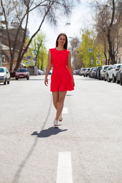 夏の通りに赤いドレスを着た若い美しい女性 — ストック写真