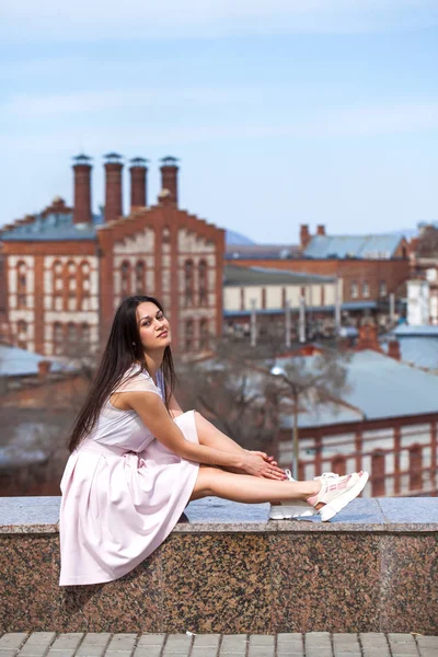 Jeune femme brune en jupe rose et chemisier blanc — Photo