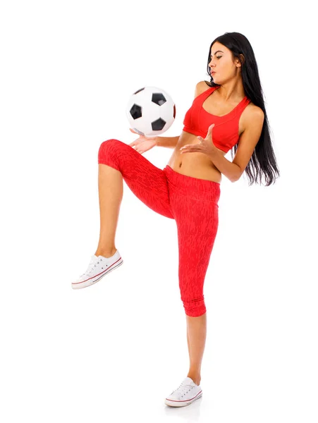 Άσκηση γυναίκα σε ένα κόκκινο αθλητικό κοστούμι με μπάλες ποδοσφαίρου — Φωτογραφία Αρχείου