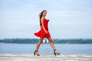 Yaz sokakta yürüyen kırmızı elbiseli genç güzel model