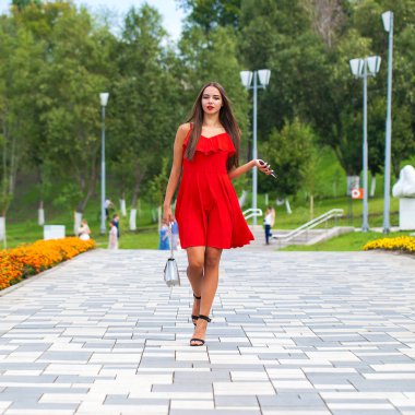 Yaz sokakta yürüyen kırmızı elbiseli genç güzel model