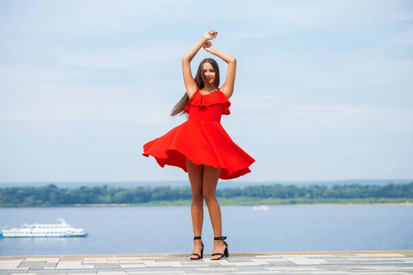 Menina bonita nova em vestido vermelho andando na rua de verão — Fotografia de Stock