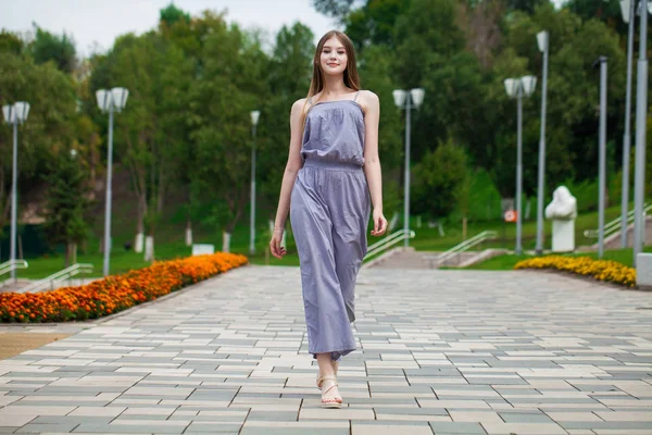 Young beautiful blonde woman in summer dress posing in summer pa — ストック写真