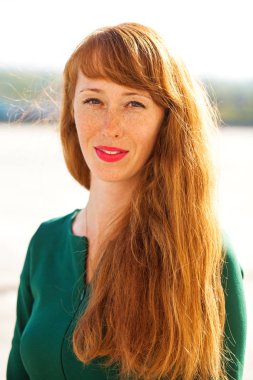 Çilli kızıl saçlı genç bir kızın portresi.