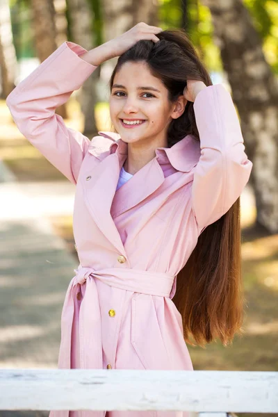 Πορτρέτο μιας νεαρής όμορφης γυναίκας με ροζ παλτό — Φωτογραφία Αρχείου