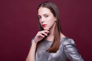 Gümüş renkli elbisesi olan genç ve güzel bir manken. 