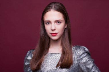 Gümüş renkli elbisesi olan genç ve güzel bir manken. 