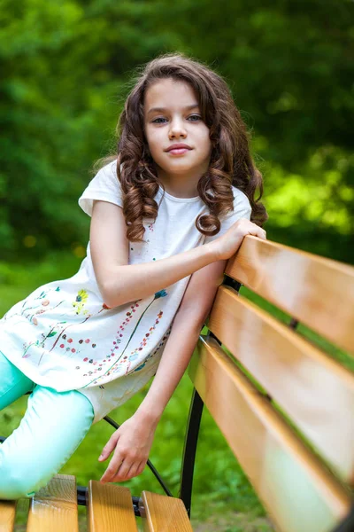 Calm brunette little girl in summer park — ストック写真