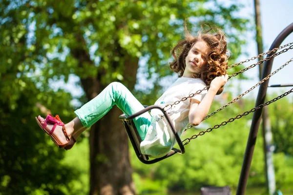 Bambina su un'altalena nel parco estivo — Foto Stock