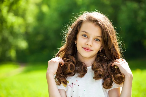 Šťastná brunetka holčička v letním parku — Stock fotografie