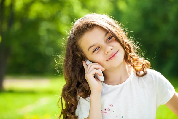 一个美丽的年轻小女孩，调用通过电话的肖像 — 图库照片