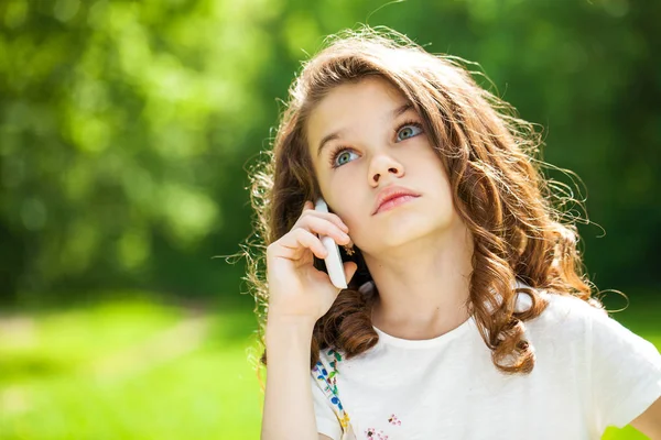 Портрет красивой маленькой девочки, звонящей по телефону — стоковое фото