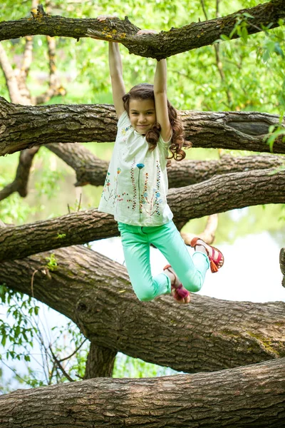 Menina feliz no tronco da árvore — Fotografia de Stock