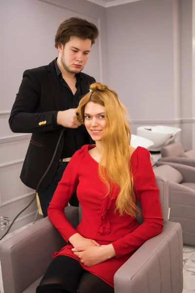 Cabeleireiro masculino styling cabelo para jovem mulher bonita — Fotografia de Stock