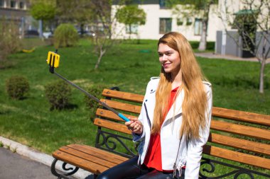 Genç güzel sarışın bir cep telefonu üzerinde kendini fotoğrafını çekmek