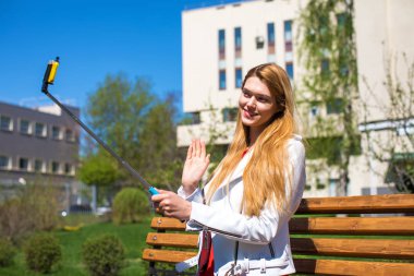 Genç güzel sarışın bir cep telefonu üzerinde kendini fotoğrafını çekmek