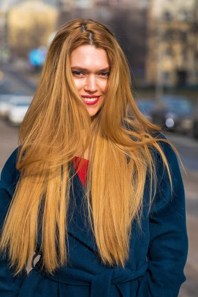 Joven hermosa mujer rubia en un abrigo azul — Foto de Stock