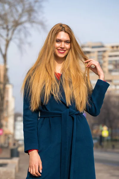 Jovem mulher loira bonita em um casaco azul — Fotografia de Stock