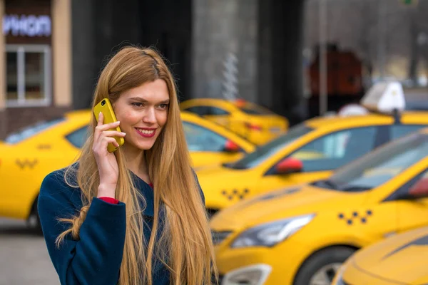 Jeune belle femme blonde appelant par taxi — Photo