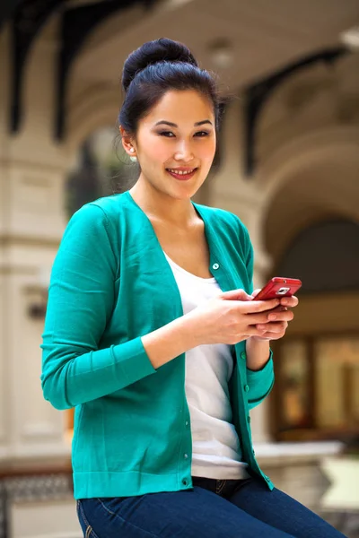 Young beautiful brunette woman writes a message on the phone — ストック写真