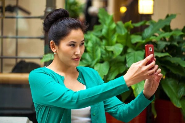 Jovem bela mulher morena faz selfie no shopping — Fotografia de Stock