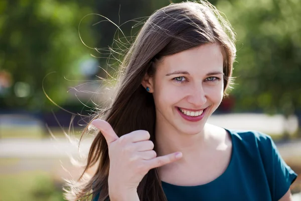 Woman making a call me sign outdoors — Stock Photo, Image