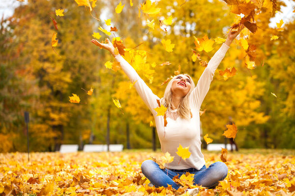 Close up portrait of young blonde beautiful woman in autumn park