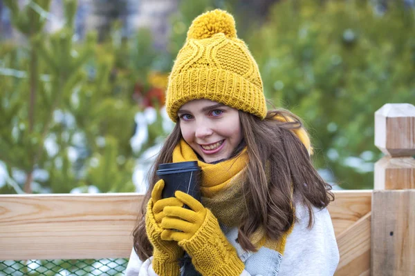 Junges Mädchen mit einem Glas Kaffee im Winterpark — Stockfoto