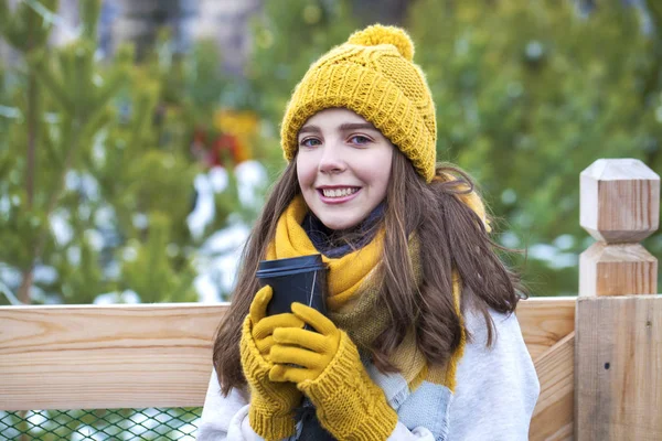 Jong meisje met een glas koffie in een winterpark — Stockfoto