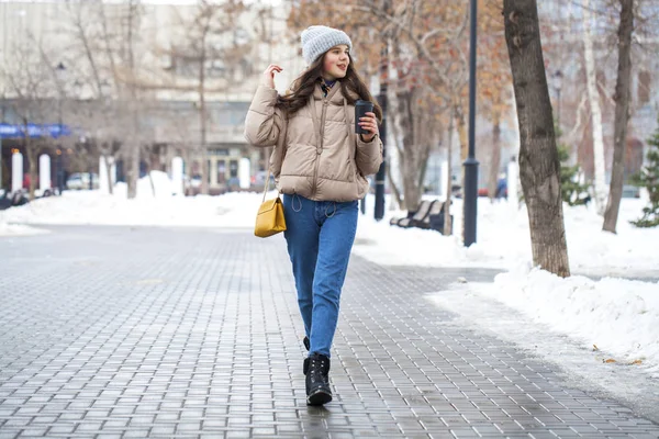 穿着蓝色牛仔裤在冬季公园散步的少女的画像 — 图库照片